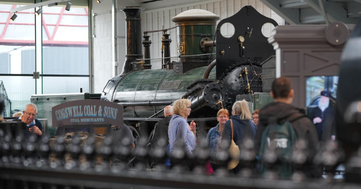 Group of people stood in front of an historic steam engine at Hopetown Darlington.